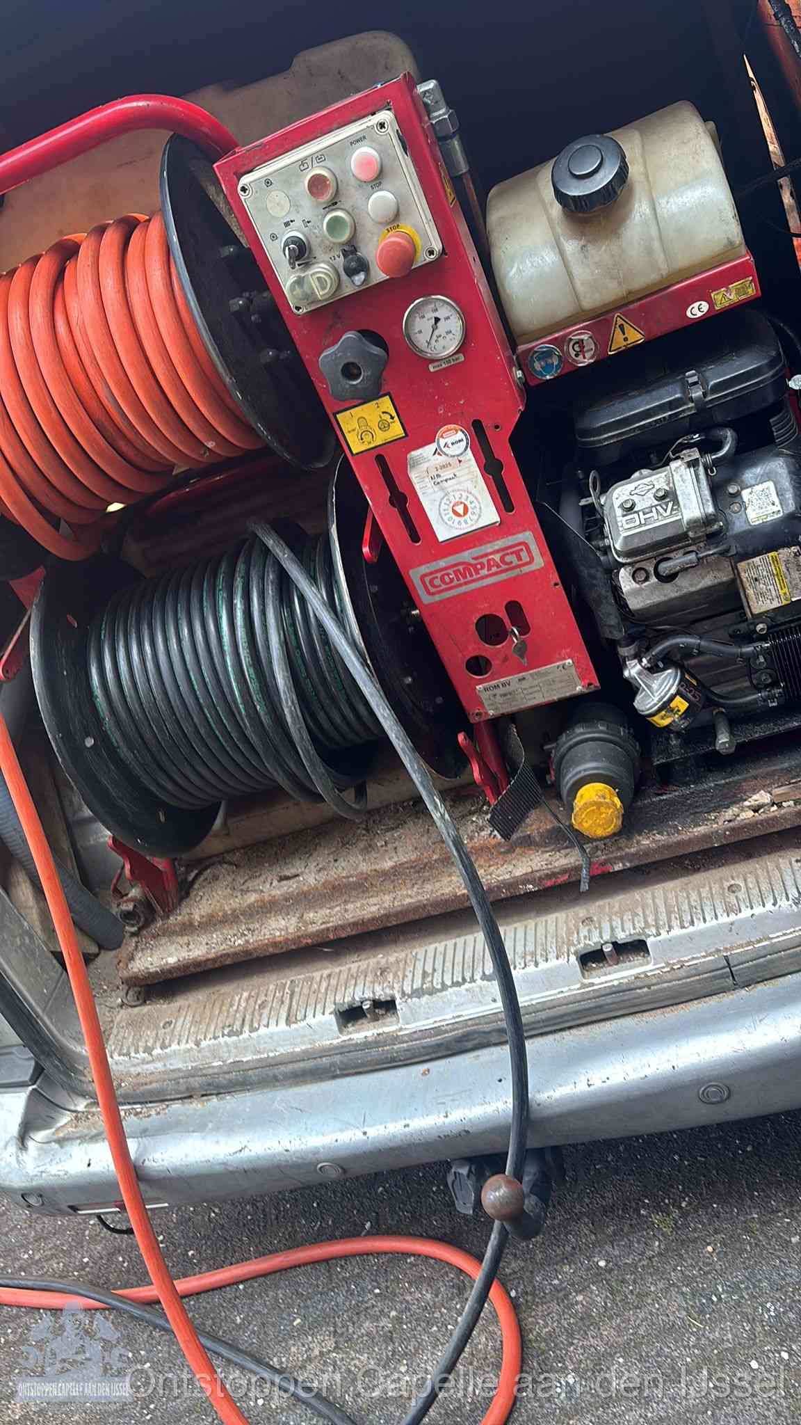 Een rood hogedruk-rioolreinigingstoestel met slangen in de laadbak van de bedrijfsbus, apparatuur voor een hardnekkige wc-verstopping in Capelle aan den IJssel