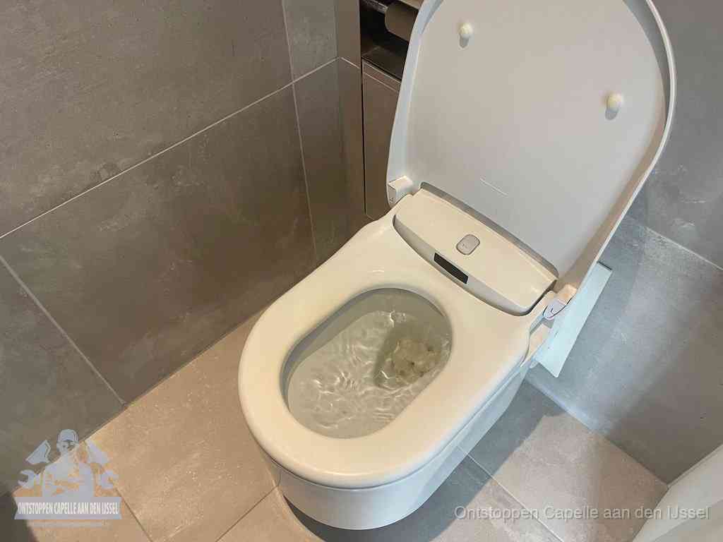 Een toiletpot vol troebel water met drijvend papier en restanten, de meest voorkomende oorzaak van een verstopte wc in Capelle aan den IJssel