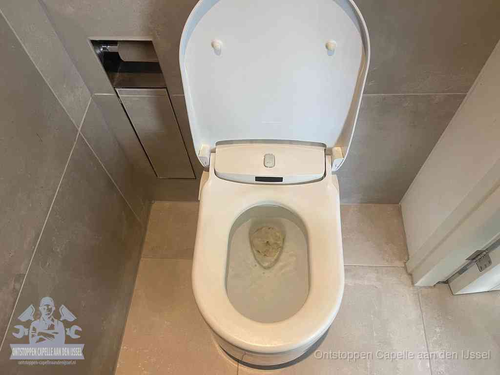 Een wit hangtoilet waarin een prop wc-papier op het water blijft drijven, een duidelijk signaal van een verstopte wc in Capelle aan den IJssel