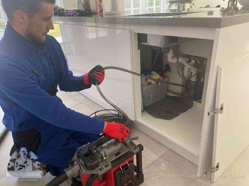 Een monteur reinigt de keukenafvoer grondig met een veermachine om terugkerende gootsteenverstoppingen te voorkomen in Capelle aan den IJssel