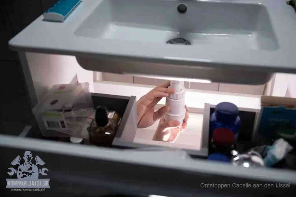 Een pompfles met zeep boven een wastafel in de toiletruimte, de warm water en afwasmiddel-methode om de wc te ontstoppen in Capelle aan den IJssel