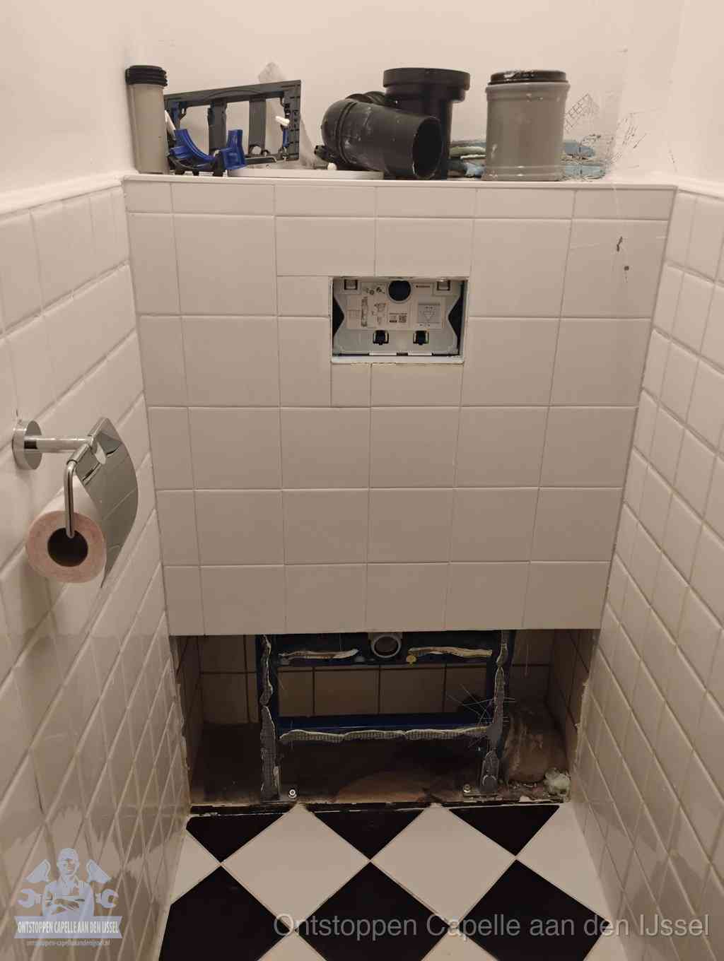 Een toiletruimte waar het hangtoilet en de inbouwreservoir-onderdelen zijn vrijgelegd voor onderhoud, periodiek nazicht voorkomt een wc-verstopping in Capelle aan den IJssel