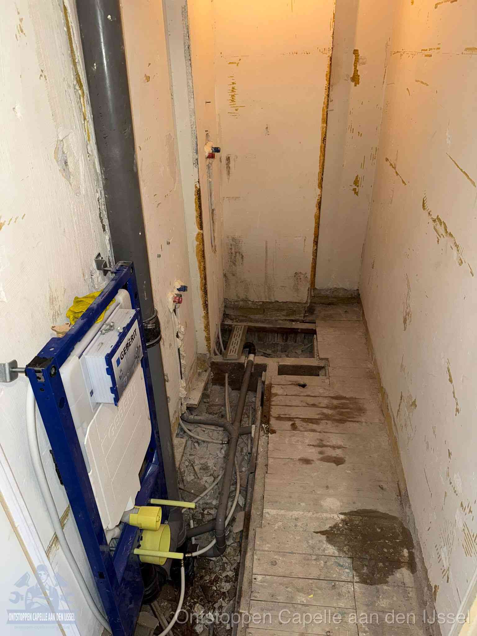 Een opgebroken toiletruimte tijdens renovatie met een Geberit inbouwreservoir en blootliggende oude afvoerleidingen, typisch voor oudere woningen in Capelle aan den IJssel